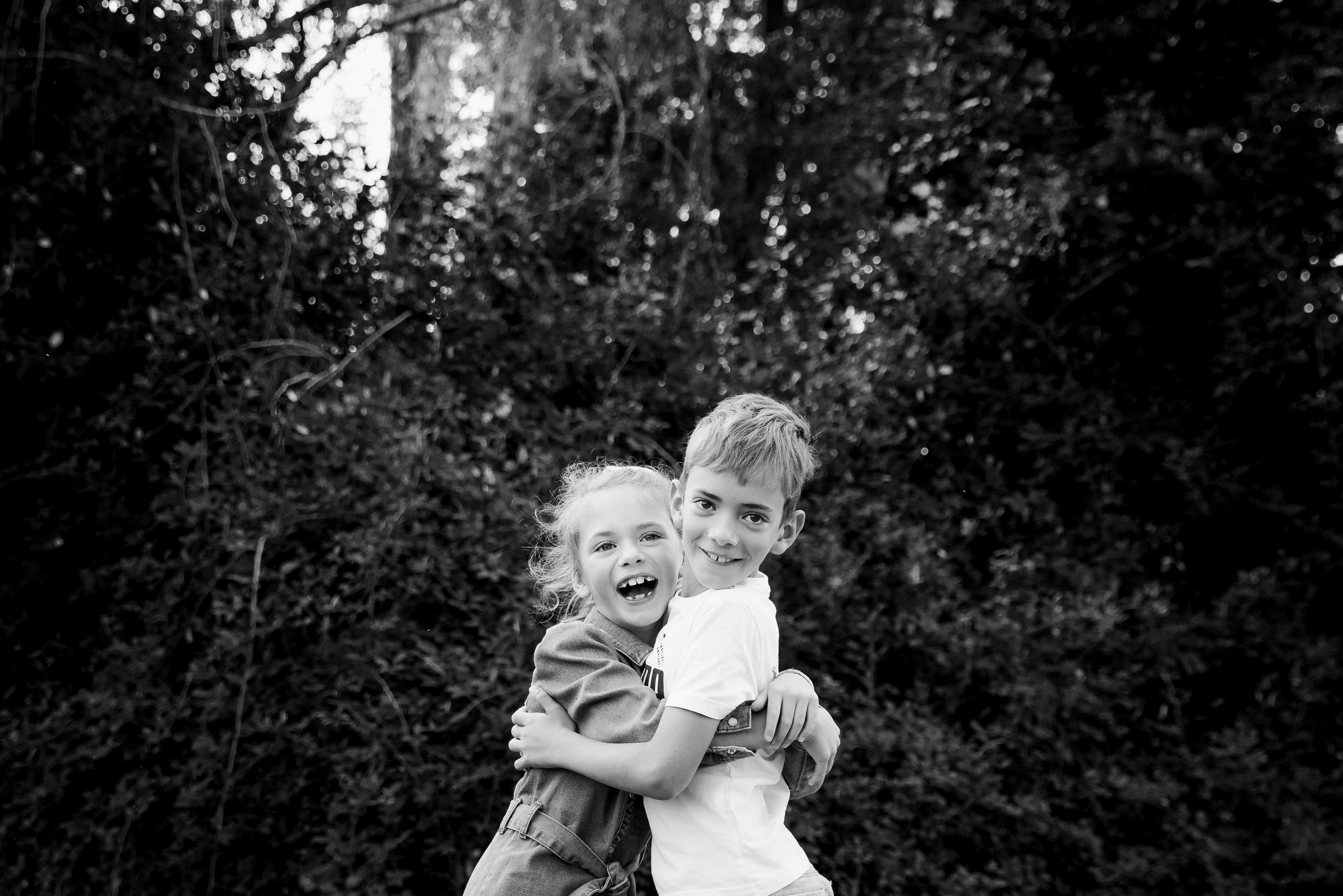 photo en noir et blanc de deux enfants frere et soeur qui rigolent