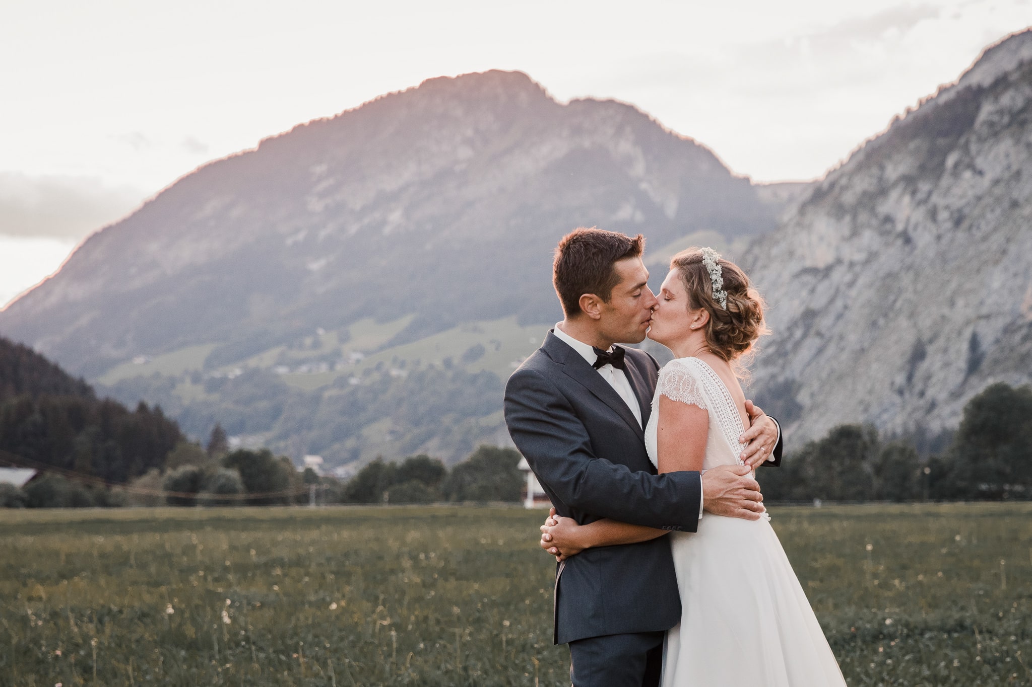 Photographe mariage couple s'embrassant devant des montagnes