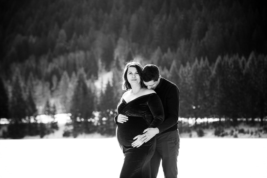 seance photo de grossesse dans la neige en hiver avec un couple qui s'embrasse noir et blanc à la montagne près de douvaine 